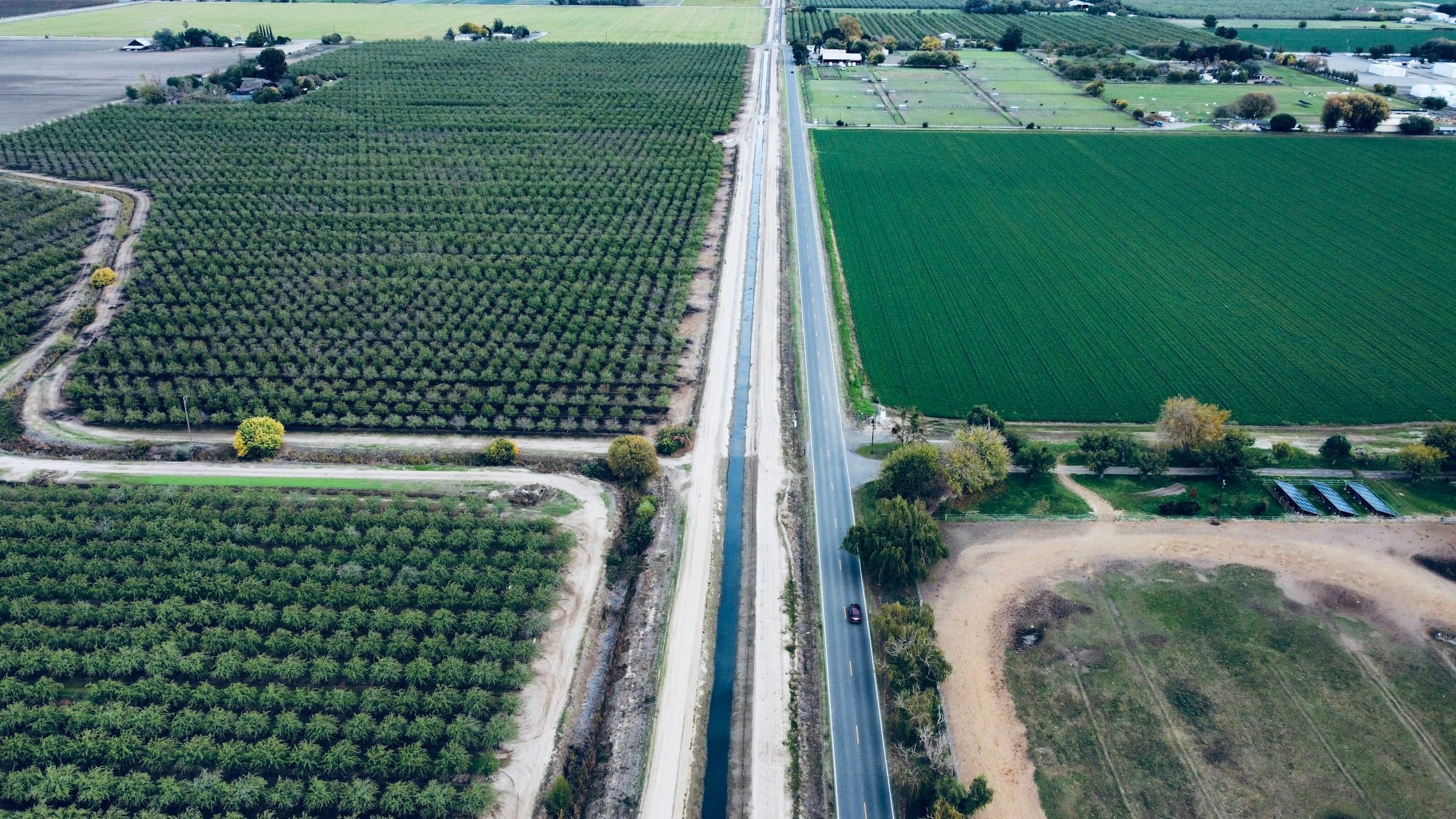 Aerial view of orchards and farm roads in an agricultural valley